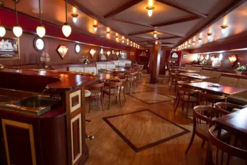 Holzgetäfelter Salon mit Bar und Tischen an Bord der Abel Tasman