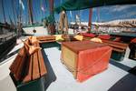 Holztisch und Bänke im Sitzbereich an Deck der Allure
