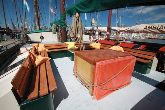 Holztisch und Bänke im Sitzbereich an Deck der Allure