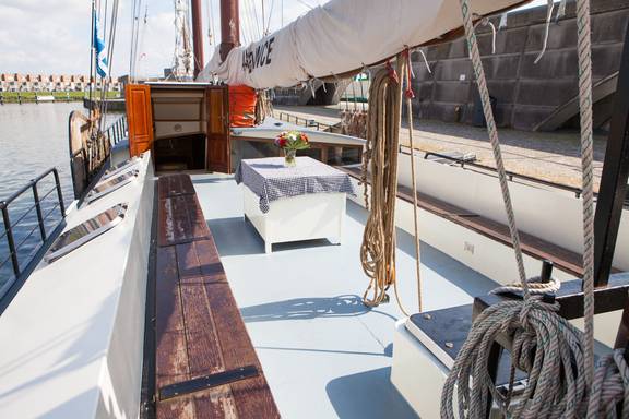 Sitzbereich mit Holzbänken und Tisch an Deck der Ambiance