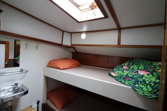 Bett und Waschbecken unter dem Oberlicht einer Kabine auf der Anna Trijntje