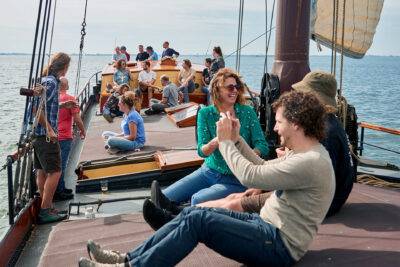 Gäste sitzen zusammen an Deck des Klippers Anna