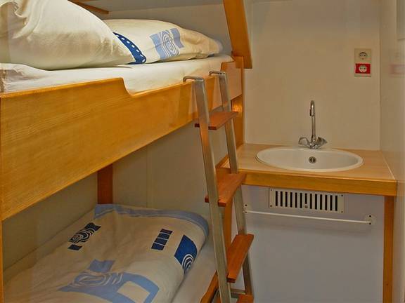 Holzetagenbett und Waschbecken in einer Kabine der Avanti