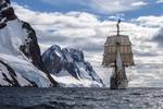 Bark Europa unter Segeln vor schneebedeckten Bergen