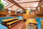 Holzesstische und blaue Sitzbänke im Salon der Bonnefooi