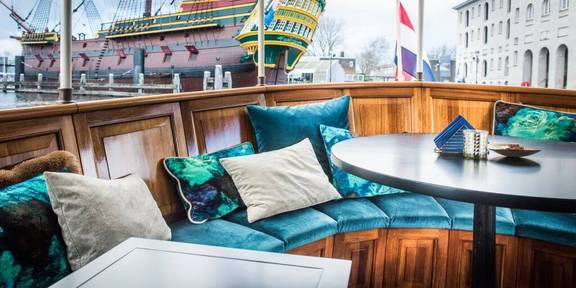 Sitzecke mit türkisfarbenen Kissen auf dem Achterdeck der Dame van Amstel