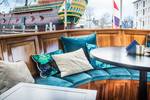 Sitzecke mit türkisfarbenen Kissen auf dem Achterdeck der Dame van Amstel