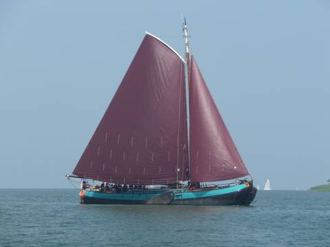 Dankbaarheid unter vollen braunen Segeln auf dem Wasser