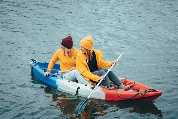 Zwei Gäste paddeln in Kanus auf dem Wasser