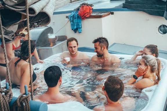 Gäste entspannen im Whirlpool an Deck der De Hester