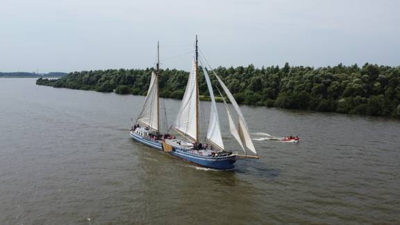 De Hester unter Segeln mit einem Beiboot längsseits