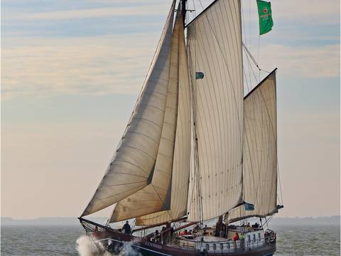 Eenhoorn unter Segeln mit aufspritzendem Bugwasser