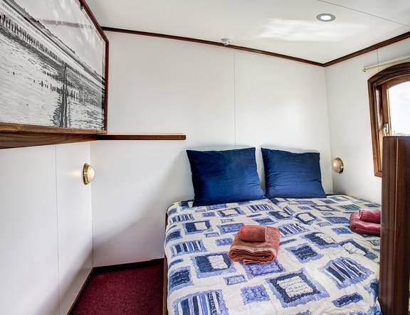 Doppelbett mit blauen Kissen in einer Kabine der Elizabeth
