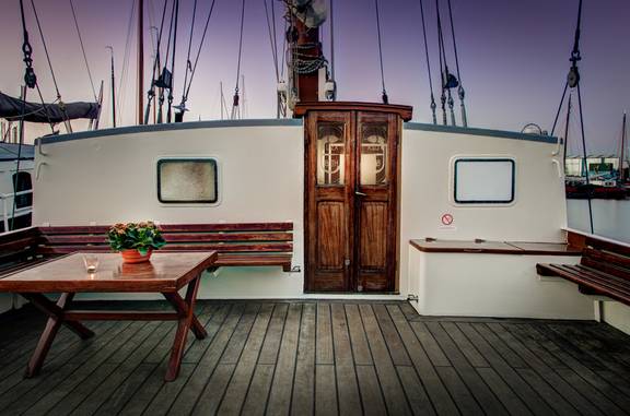 Sitzbereich an Deck der Elizabeth mit Holzbänken am Abend