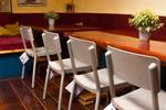 Salon der Gouwzee mit Holzesstischen und roten Sitzbänken