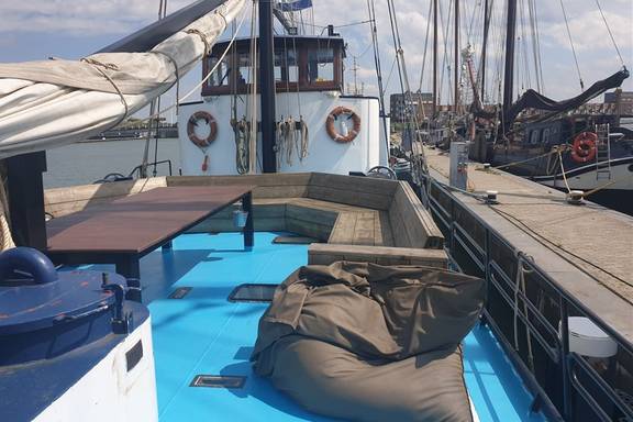 Holzbänke, Tisch und Sitzsack an Deck der Grietje