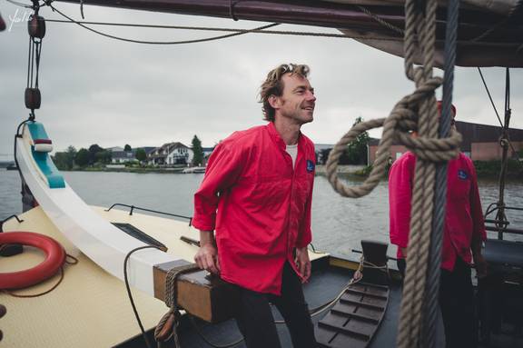 Segler bedient eine Leine an Deck der Helena