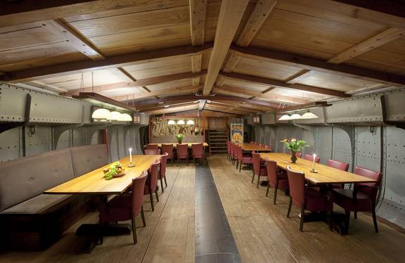 Salon der Helena mit langen Holzesstischen