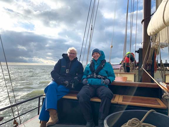 Gäste sitzen während des Segelns an Deck der Johanna Engelina