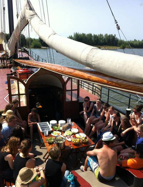 Gäste teilen eine Mahlzeit im Sitzbereich an Deck der Korevaer