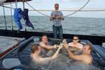Gäste stoßen im Whirlpool an Deck der Mare fan Fryslân an