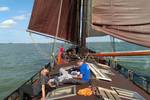 Gäste entspannen an Deck der Medusa unter braunen Segeln