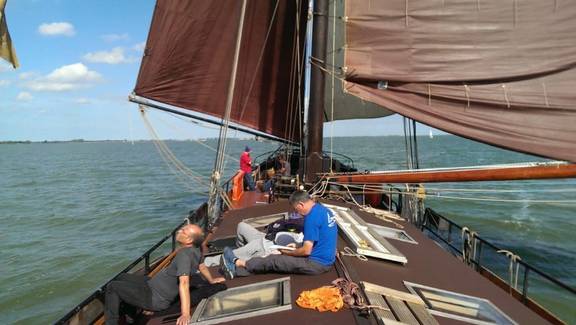 Gäste entspannen an Deck der Medusa unter braunen Segeln