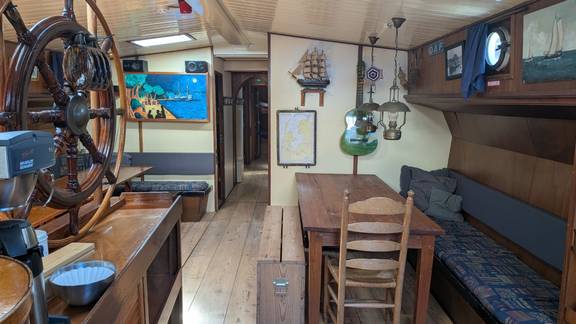 Salon der Meridiaan mit Holztischen und blauen Sitzbänken