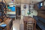 Salon der Meridiaan mit Holztischen und blauen Sitzbänken