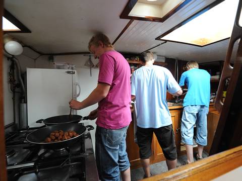 Gäste kochen gemeinsam in der Kombüse der Nieuwe Zorg