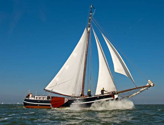 Tjalk Orion unter weißen Segeln auf dem Wasser