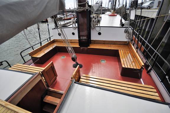 Sitzbereich an Deck der Passaat mit Holzbänken und rotem Boden