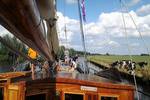 Blick über das Deck der Pelikaan an einem grünen Ufer