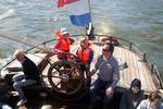 Gäste am Steuerrad auf dem Achterdeck der Pelikaan