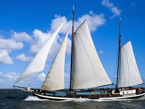 Zweimastklipper Poseidon unter weißen Segeln auf dem Wasser