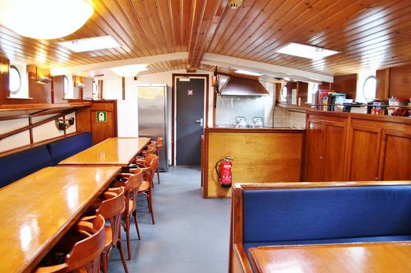 Salon der Rival mit Holztischen und blauen Sitzbänken