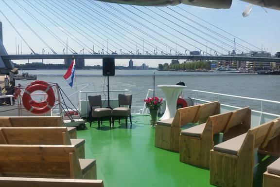 Holzbänke auf dem grünen Deck der Smaragd 1 mit Blick auf die Erasmusbrücke