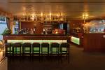 Geräumiger Salon der Smaragd 1 mit Bar und grünen Barhockern