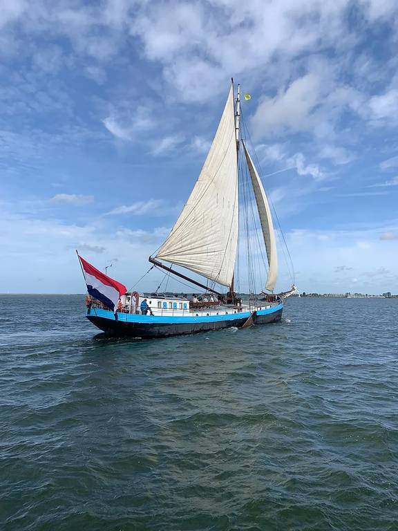 Spartivento mit weißem Segel und niederländischer Flagge auf offenem Wasser