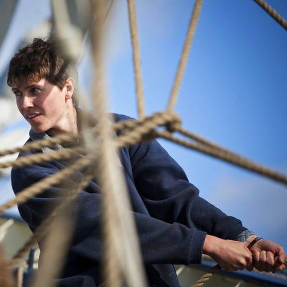 Segler bedient eine Leine an Bord der Thalassa