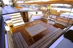 Sitzbereich mit Holzbänken und Tisch an Deck der Tsjerk Hiddes