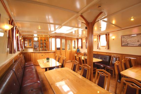 Salon der Tsjerk Hiddes mit Holztischen und Ledersitzbänken