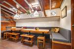 Sitzecke mit Holztischen und Bänken in der Vriendentrouw