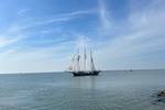 Dreimaster Vrijheid segelt auf ruhigem Wasser entlang der Küste