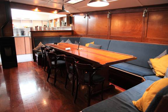 Salon der Vrijheid mit Holzesstischen und Sitzbänken