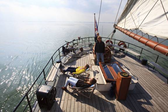 Gäste entspannen an Deck der 't Wapen fan Fryslân beim Segeln
