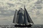 Klipper Waterman unter Segeln auf glitzerndem Wasser unter dunklen Wolken