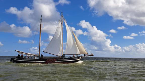 Klipper Waterman mit weißen Segeln unter blauem Himmel mit Wolken