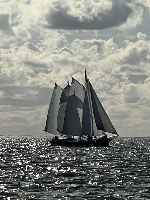 Klipper Waterman unter Segeln auf glitzerndem Wasser unter dunklen Wolken