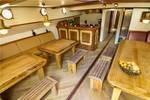 Salon der Gulden Belofte mit Holzesstischen und Sitzbänken